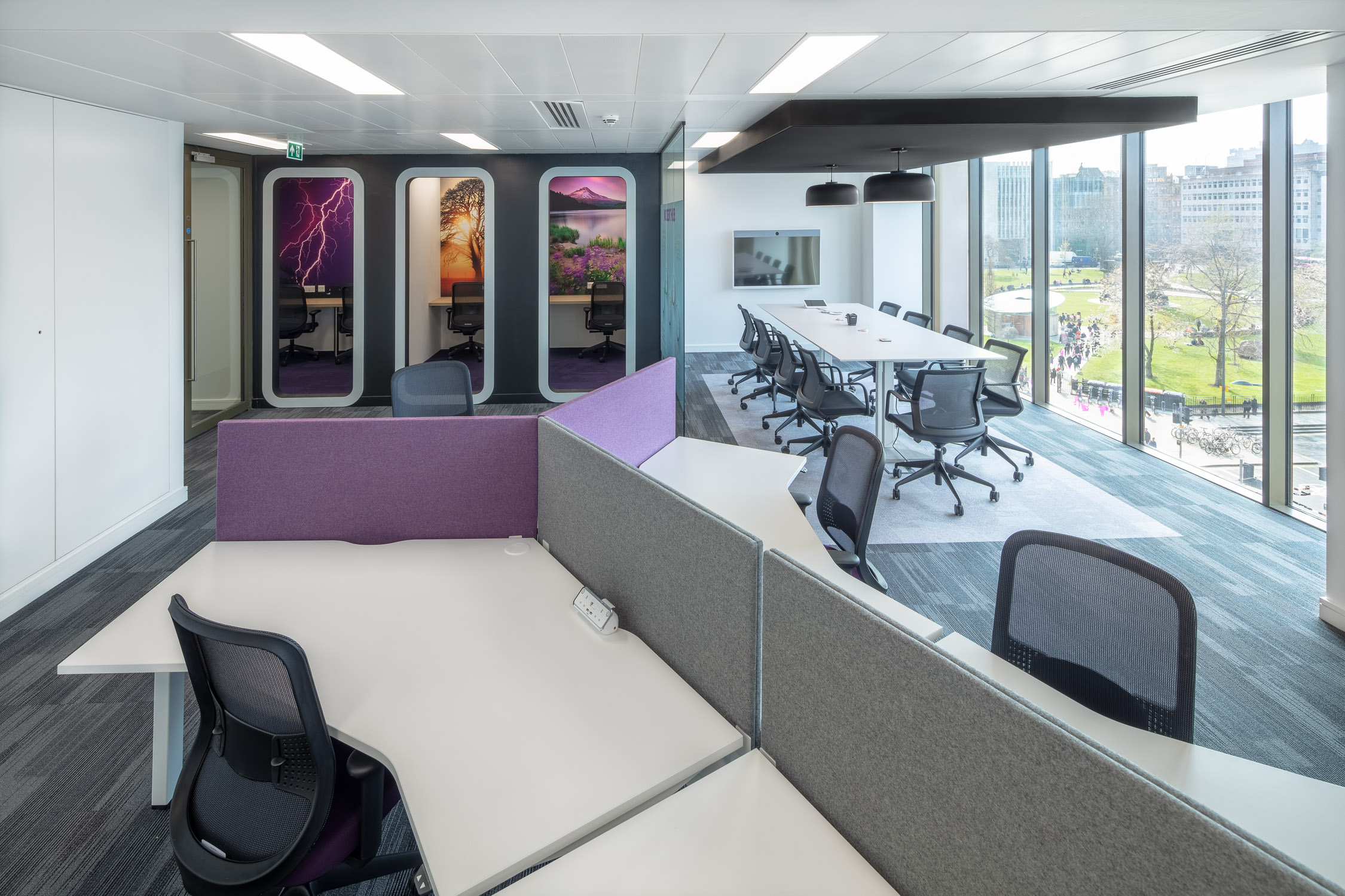 Open-plan office with acoustic solutions including desk dividers and meeting pods